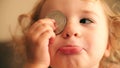 Cute little girl plays with a bitcoin token or coin. Cryptocurrency noob concept