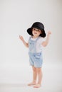 Cute little girl plays with a black hat. the child tries on mothers clothes.