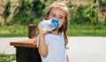 cute little girl plays outdoors on the summer , and walks around the park, happy childhood