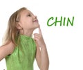 Cute little girl pointing her chin in body parts learning English words at school Royalty Free Stock Photo