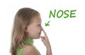 Cute little girl pointing her nose in body parts learning English words at school Royalty Free Stock Photo