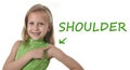 Cute little girl pointing her shoulder in body parts learning English words at school Royalty Free Stock Photo