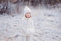 Cute little girl portrait on the walk in winter snowy frozen forest