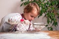 A cute little girl prepares her first tasty pie with a sieve for Royalty Free Stock Photo