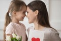 Cute little girl present flowers and postcard for young mom Royalty Free Stock Photo