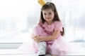 Cute little girl in a princess costume. Pretty child preparing for a costume party. Beautiful queen in gold crown. Royalty Free Stock Photo