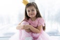 Cute little girl in a princess costume. Pretty child preparing for a costume party. Beautiful queen in gold crown. Royalty Free Stock Photo