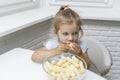 Child eating corn sticks at the kitchen table Royalty Free Stock Photo