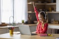 Cute Little Girl Raising Hand During Online Lesson On Laptop At Home Royalty Free Stock Photo