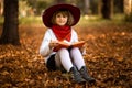 Cute little girl read interesting book in autumn Royalty Free Stock Photo