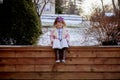 Cute little girl reading the Bible with an excited face in the winter park Royalty Free Stock Photo