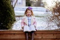 Cute little girl reading the Bible with an excited face in the winter park Royalty Free Stock Photo