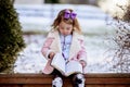 Cute little girl reading the Bible with an excited face in the winter park Royalty Free Stock Photo