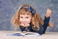Cute little girl reading book while lying on floor Royalty Free Stock Photo