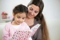 Cute little girl reading book with mother Royalty Free Stock Photo