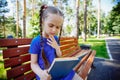 Cute little girl is reading a book outdoors Royalty Free Stock Photo