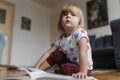 Cute little girl reading book sitting on the floor. Royalty Free Stock Photo