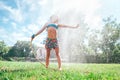 Cute little girl refresh herself from garden watering hose Royalty Free Stock Photo