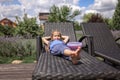 A cute little girl relaxing on the chaise longue at green garden outside, home feeling Royalty Free Stock Photo