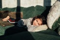 Cute little girl resting at home. Young beautiful kid lying on sofa. Royalty Free Stock Photo