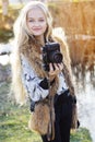 Cute little girl is resting near lake with camera Royalty Free Stock Photo