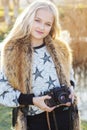 Cute little girl is resting near lake with camera Royalty Free Stock Photo