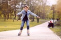 Young girl rides inline skating rollerblades in the park