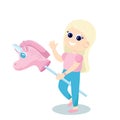A cute little girl rides a pink unicorn toy on a stick. The girl is very happy, she smiles and waves hello.