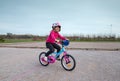 cute little girl riding a bicycle in the countryside in spring