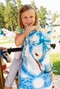 Cute little girl riding on a carousel Royalty Free Stock Photo