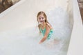 Cute little girl riding down a water slide at a water park Royalty Free Stock Photo