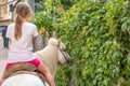 Cute little girl riding on a pony in Chinese countryside Royalty Free Stock Photo