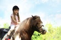 Cute little girl riding pony outdoors Royalty Free Stock Photo