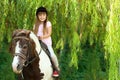 Cute little girl riding pony in park Royalty Free Stock Photo