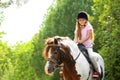 Cute little girl riding pony in park Royalty Free Stock Photo