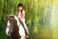 Cute little girl riding pony in park Royalty Free Stock Photo