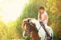 Cute little girl riding pony in park Royalty Free Stock Photo