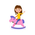 A cute little girl is riding a rocking horse isolated on a white background Royalty Free Stock Photo