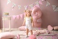 Cute little girl in room decorated for second birthday party