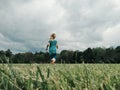 Cute little girl run on meadow. Kids girl legs feet in rain boots. Freedom innocence and adolescense concept. Summer fun outdoors Royalty Free Stock Photo