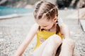 Cute little girl running along the seashore against a clear blue sea and rejoices in the rays of the summer sun Royalty Free Stock Photo