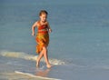 Cute little girl running on beach in sunset Royalty Free Stock Photo