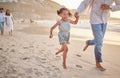 Cute little girl running hand in hand with her mixed race dad on the beach. A daughter and her father holding hands Royalty Free Stock Photo