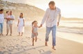 Cute little girl running hand in hand with her mixed race dad on the beach. A daughter and her father holding hands Royalty Free Stock Photo