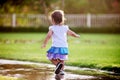 Cute little girl running through puddles Royalty Free Stock Photo