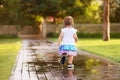 Cute little girl running through puddles Royalty Free Stock Photo