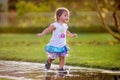 Cute little girl runnung through puddles Royalty Free Stock Photo