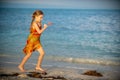 Cute little girl running on sandy beach in sunset light. Royalty Free Stock Photo