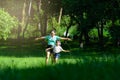 Cute little girl runs with her mother spreading her arms as if flying in a spring garden. Young mother playing with her daughter Royalty Free Stock Photo