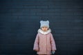 Cute little girl is sad in despair standing against the dark wall Royalty Free Stock Photo